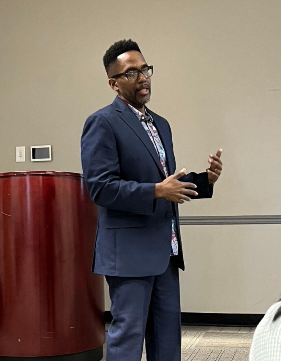 Garrick Gibson presenting to an audience, demonstrating his experience as a cross-functional design leader and facilitator in healthcare and benefits organizations